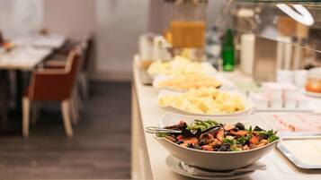 A buffet with various food items including salads, fruits, and beverages.