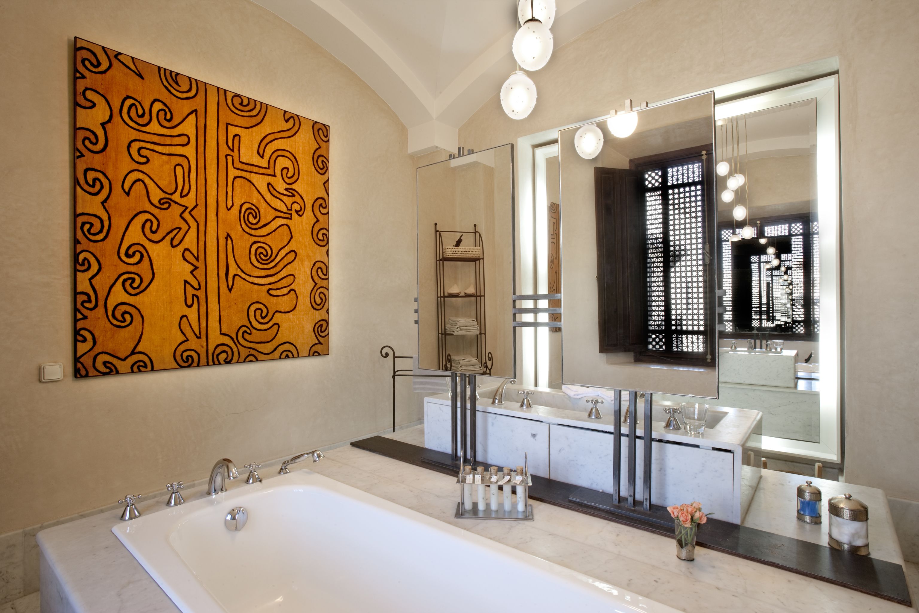 A modern bathroom with a large bathtub, dual sinks, and a large mirror.