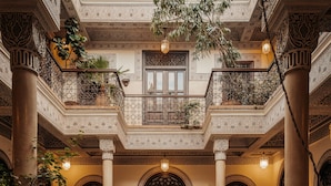 An ornate courtyard with a central fountain, surrounded by potted plants and columns. - La Villa Des Orangers - Relais & Châteaux (Marrakech)