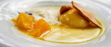 A dessert with a smooth, creamy texture and a slice of orange on a white plate.