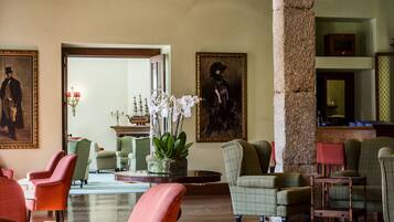 Un vestíbulo amplio con vigas de madera, asientos cómodos y obras de arte en las paredes.