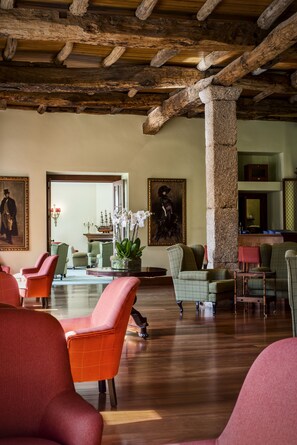 A spacious lobby with wooden beams, comfortable seating, and artwork on the walls.