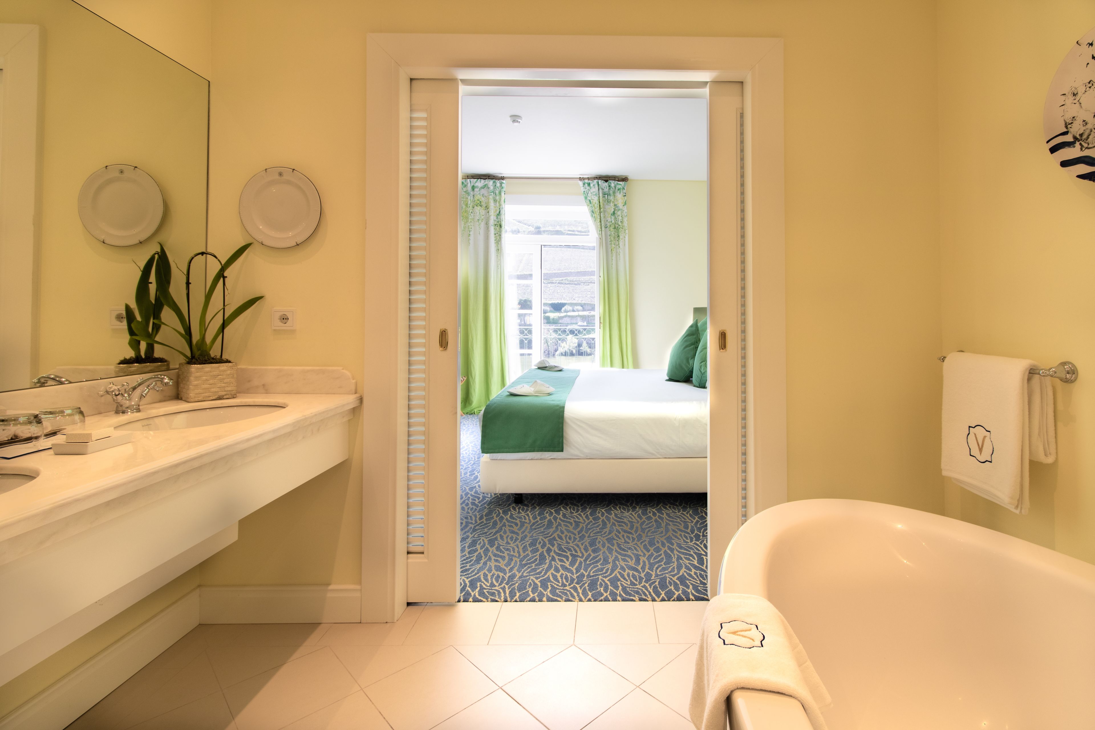 Un baño con bañera, lavamanos y espejo.