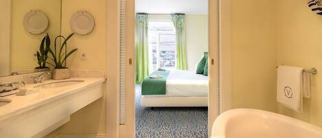 A bathroom with a bathtub, a sink, and a mirror.