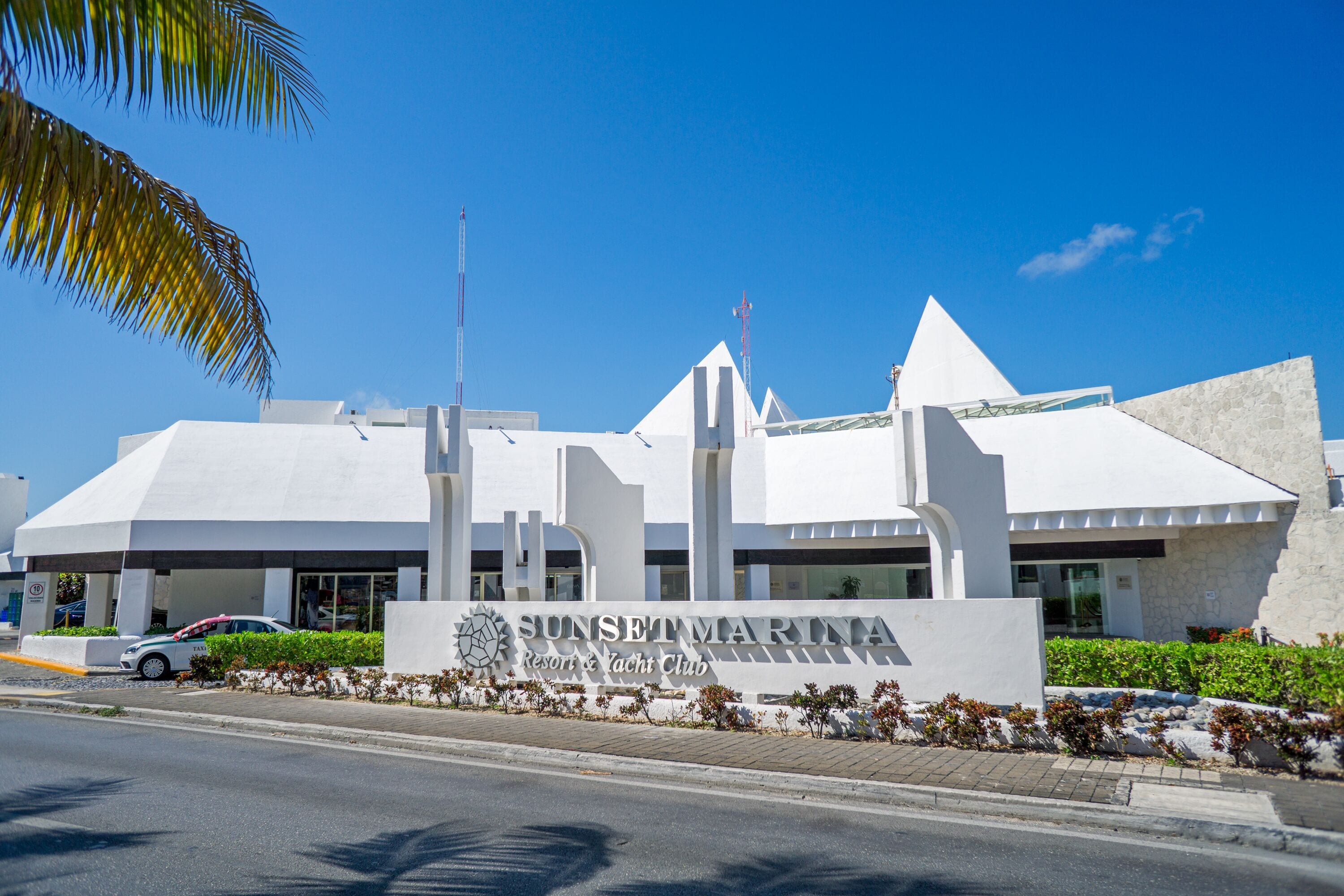 Un bâtiment moderne sur lequel on peut lire l’inscription : « Sunset Marina Resort & Yacht Club ».