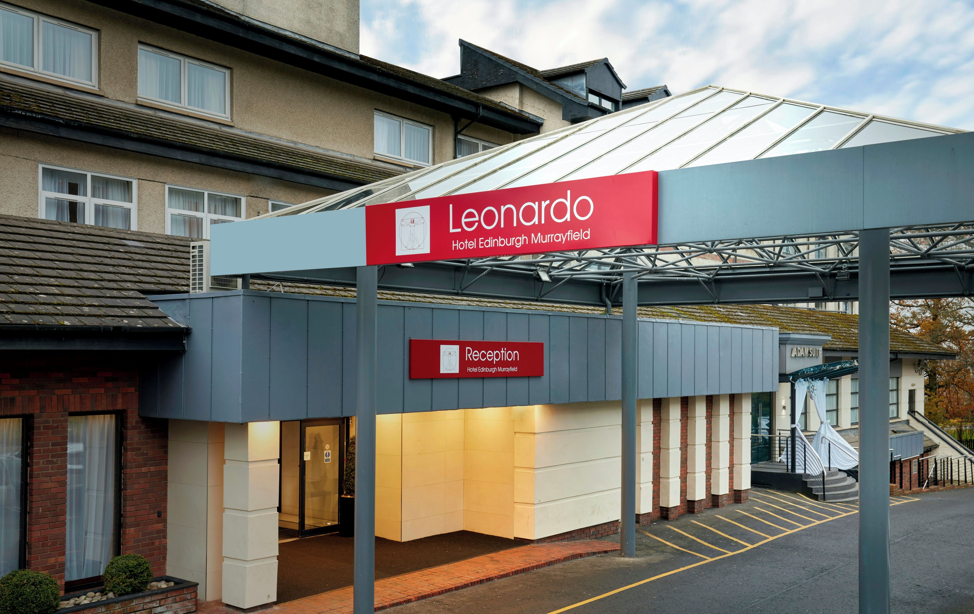 The exterior of the Leonardo Hotel Edinburgh Murrayfield with a reception sign, a covered entrance, and a parking area.