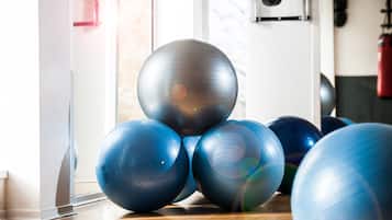 Una sala de gimnàstica amb pilotes d'exercici i un sac d'entrenament.
