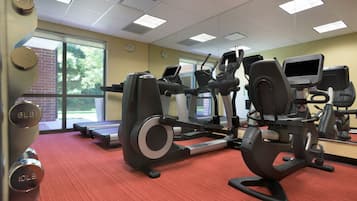 A gym with treadmills, elliptical machines, and weight machines.