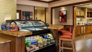 A breakfast bar with a glass display case, seating area, and a coffee station. - Hyatt Place Baltimore/Owings Mills (Owings Mills)