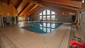 An indoor swimming pool with a wooden ceiling and large windows. - Quality Inn near Medical Center (Rochester)
