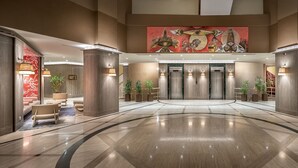 A spacious lobby with a polished floor, a central elevator, and a large abstract mural on the ceiling. - Polat Palandoken (Erzurum)
