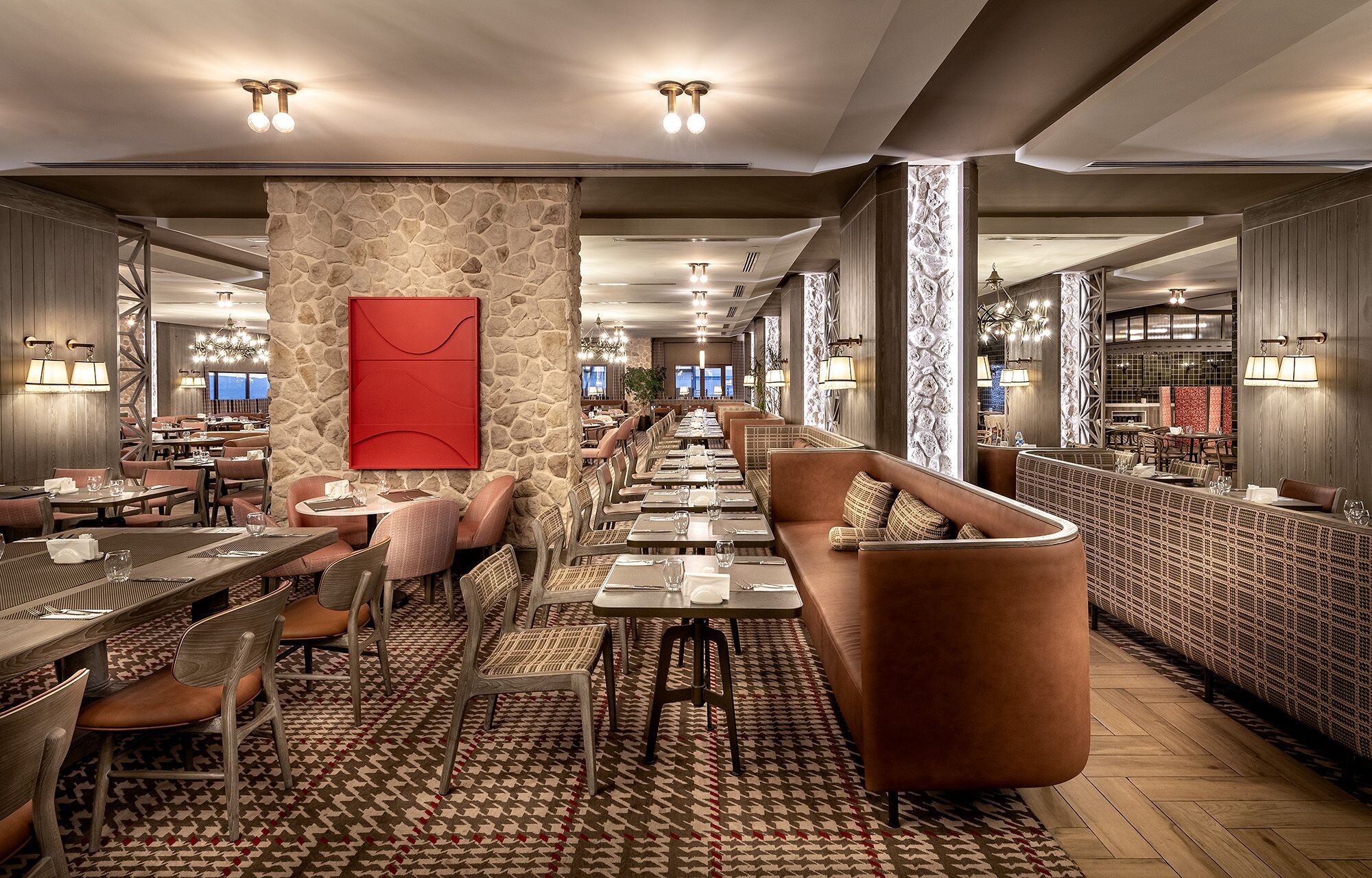 A modern restaurant with a long counter, booths, and a patterned floor.