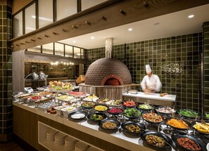 A buffet with a variety of dishes and a brick oven pizza station. - Polat Palandoken (Erzurum)