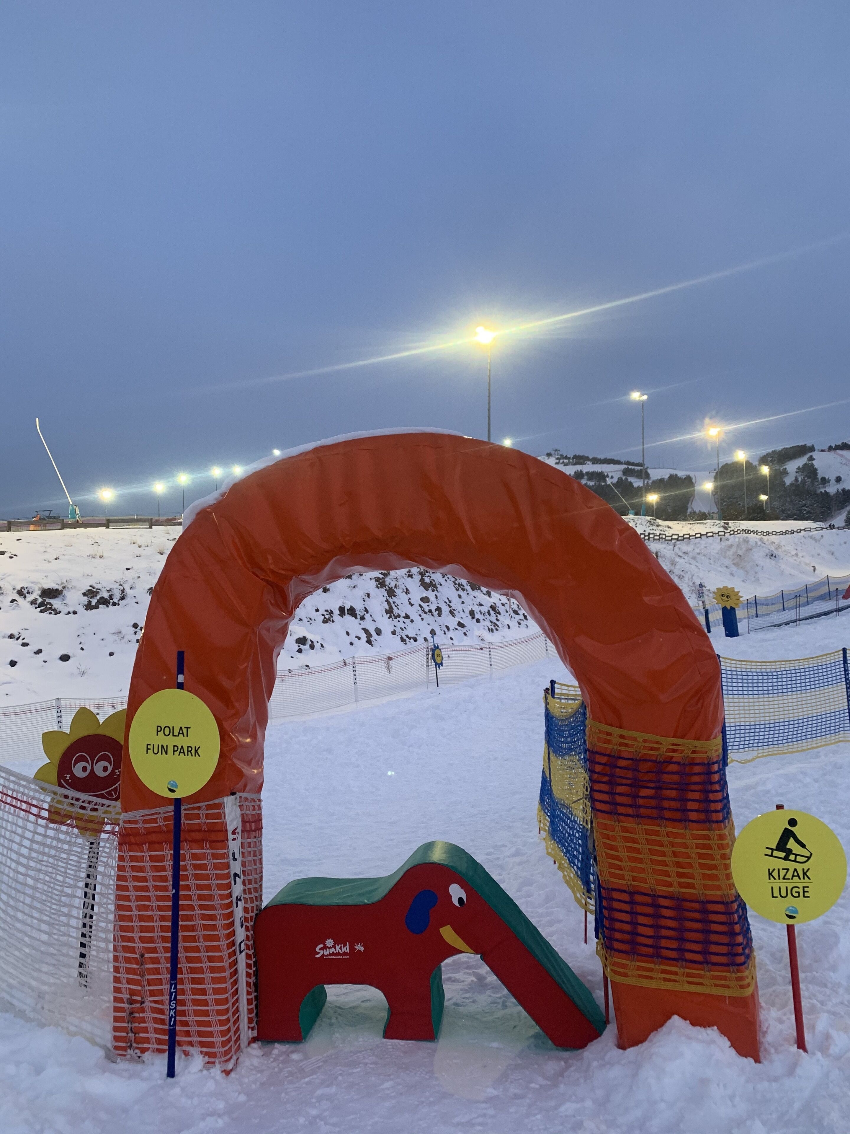 An inflatable archway at a park entrance with signs for 'Polat Fun Park' and 'Kizak Luge'.