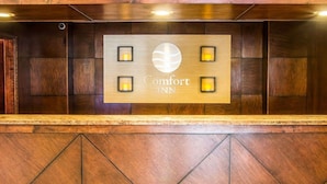 Um balcão de recepção com uma placa que diz "Comfort INN" e quatro luzes iluminadas.