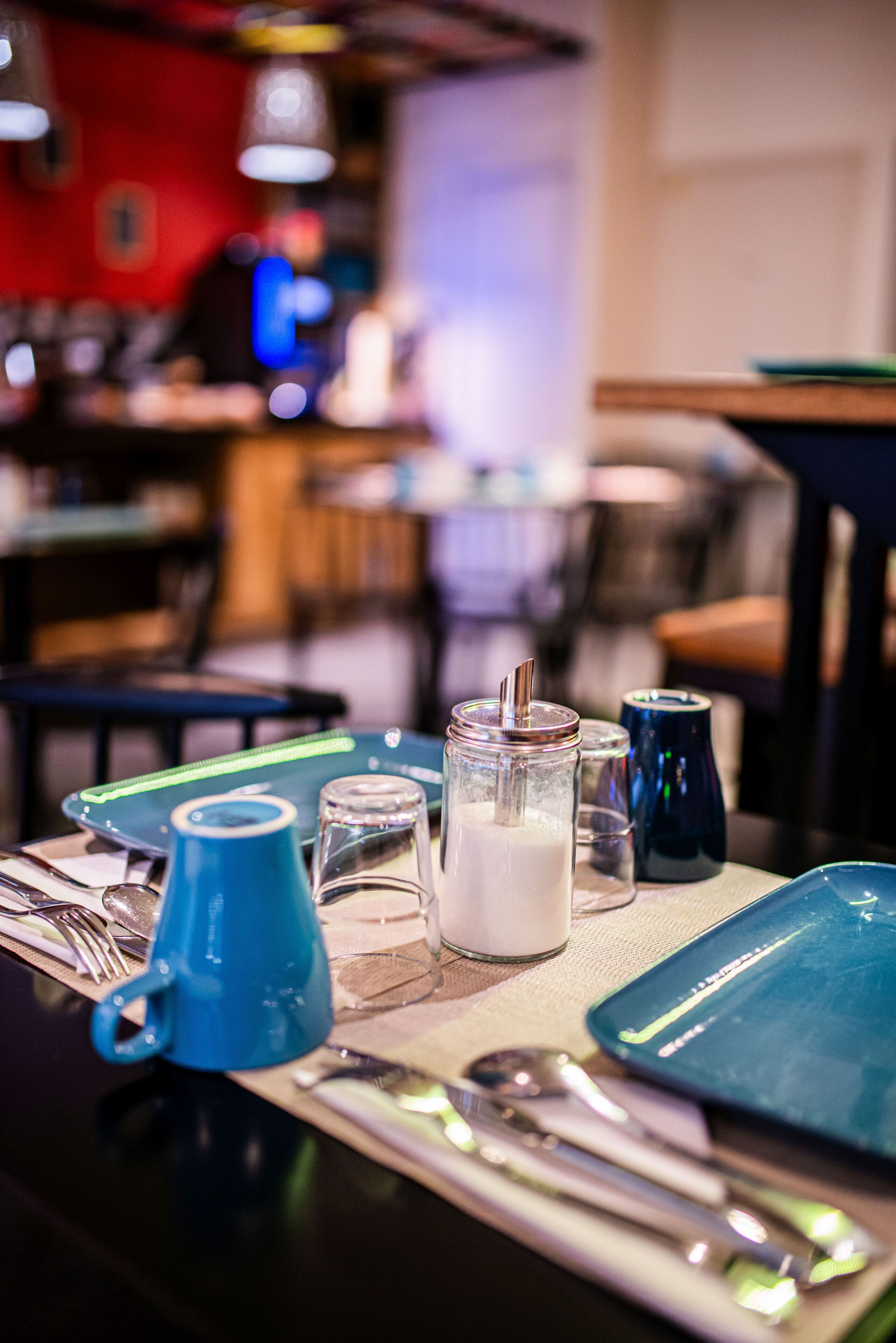 A table set with a glass of milk, a blue mug, and a smartphone.