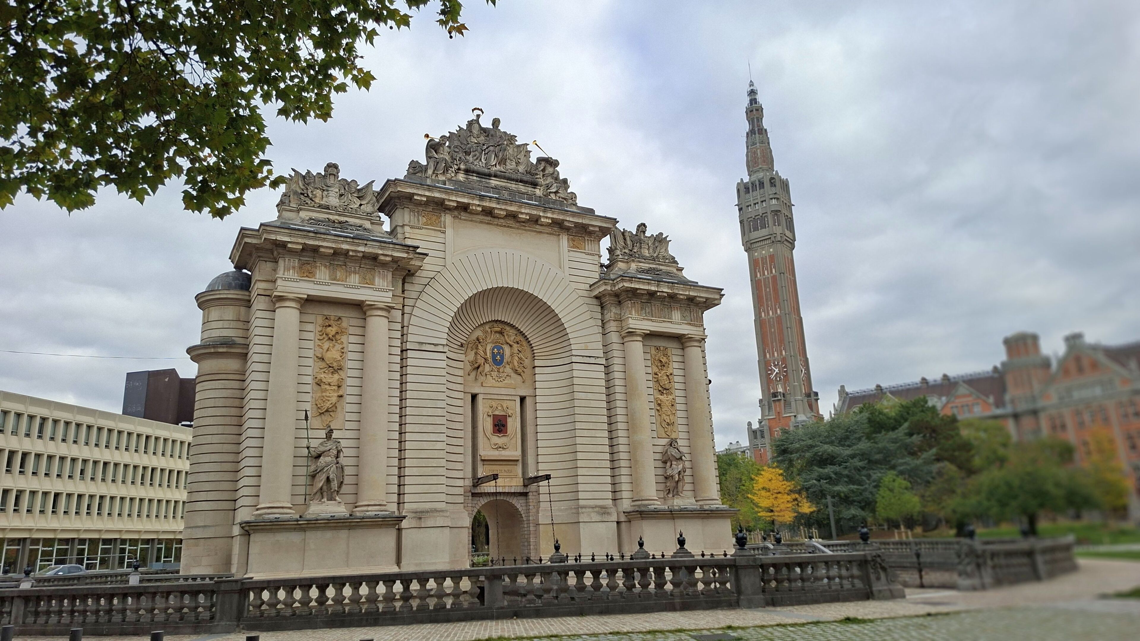 A historic building with classical architecture, featuring a prominent clock tower and statues.