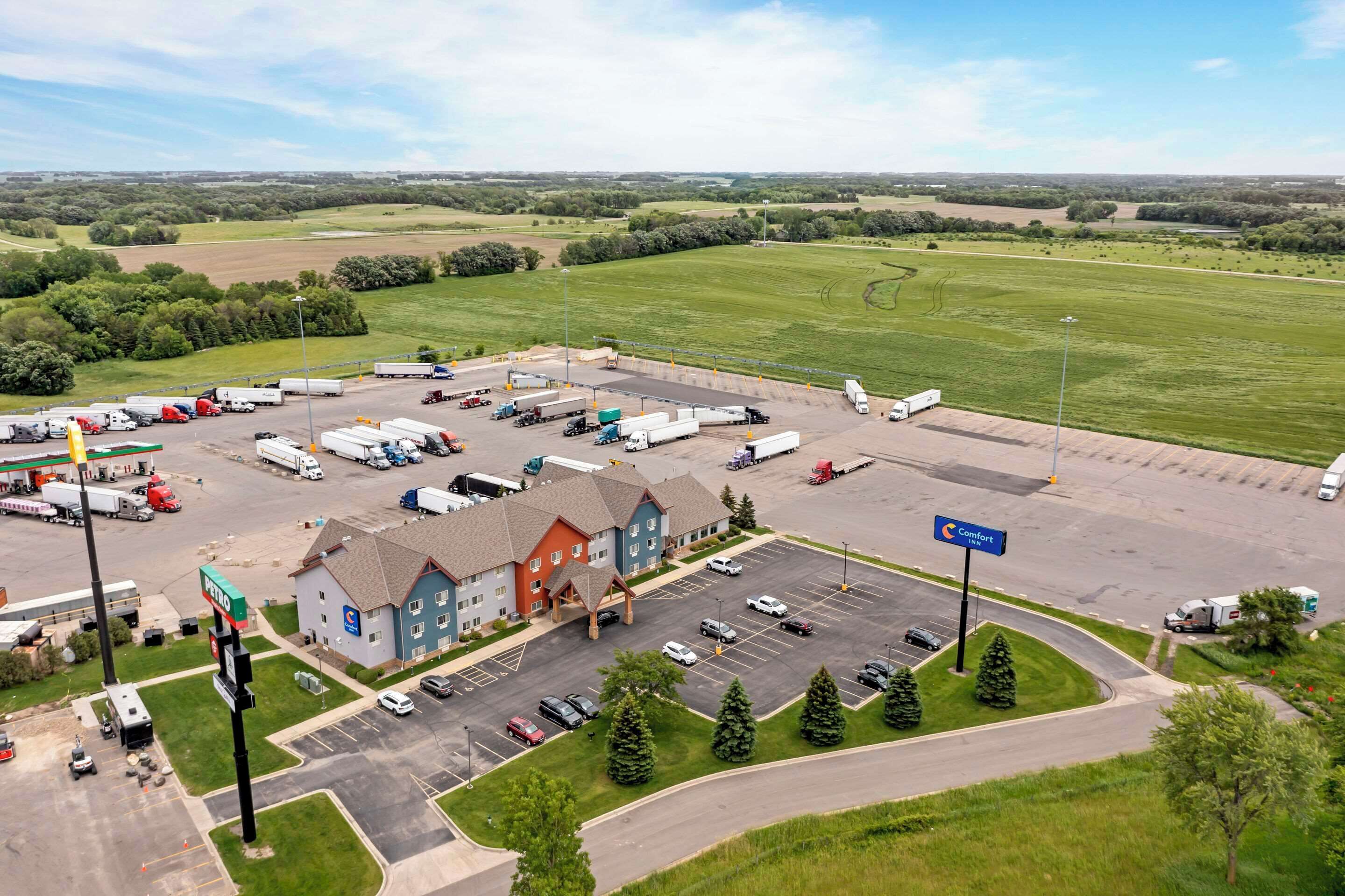 A large parking area with multiple trucks and cars, a Comfort Inn, and a gas station.