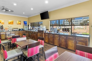 A restaurant with wooden cabinets, a counter, and a large window.