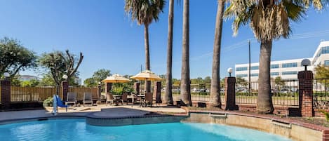 Una piscina al aire libre, tumbonas