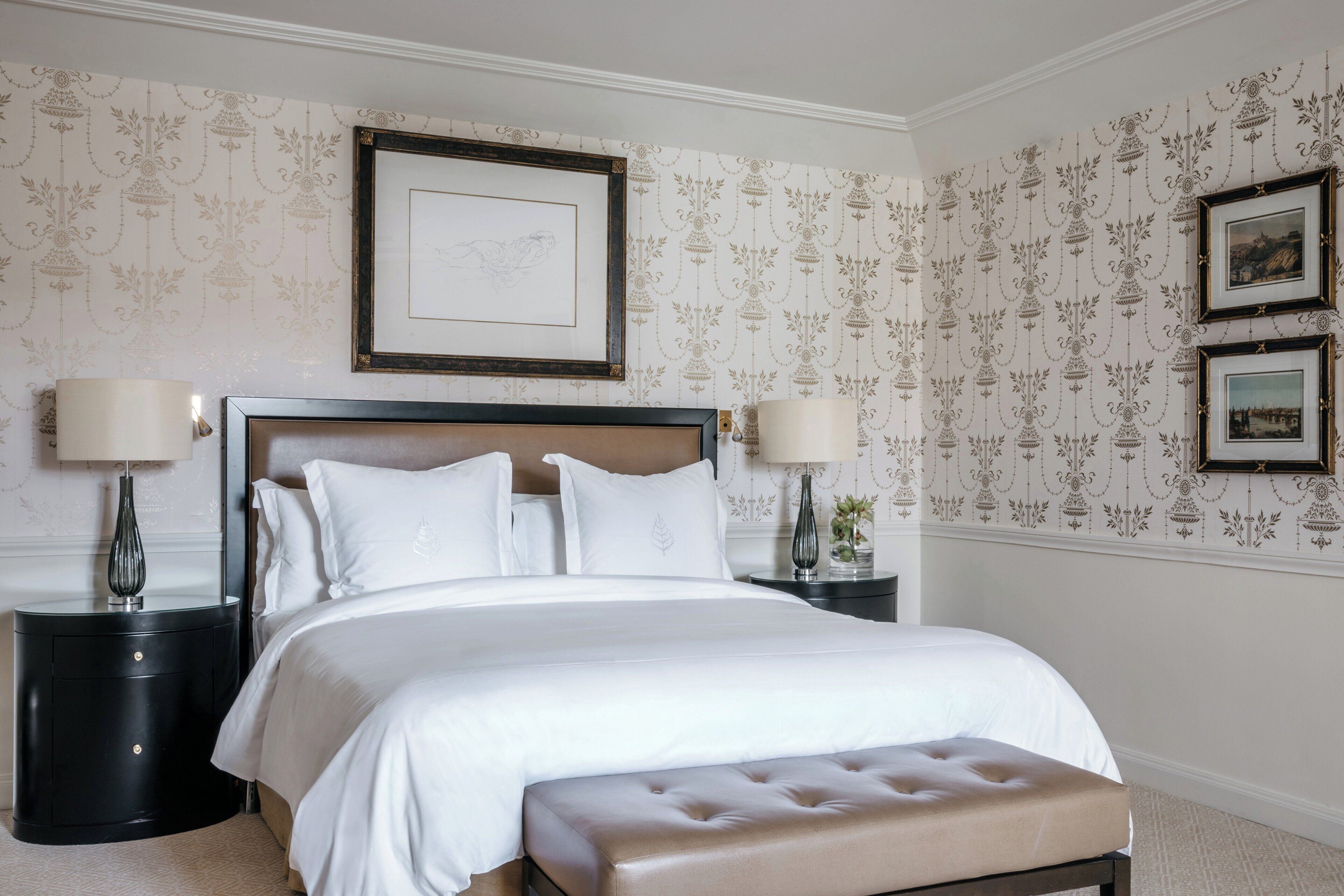 A neatly arranged bedroom with a large bed, two bedside tables, and a headboard.