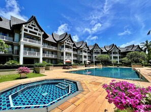 A hotel with multiple-story buildings, a swimming pool, and well-maintained gardens. - Allamanda Laguna Phuket by RESAVA (Choeng Thale)
