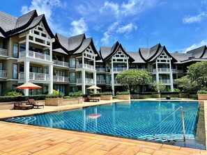 A hotel with multiple-story buildings, a swimming pool, and outdoor seating areas. - Allamanda Laguna Phuket by RESAVA (Choeng Thale)