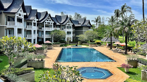 A hotel with a swimming pool, multiple balconies, and lush greenery. - Allamanda Laguna Phuket by RESAVA (Choeng Thale)