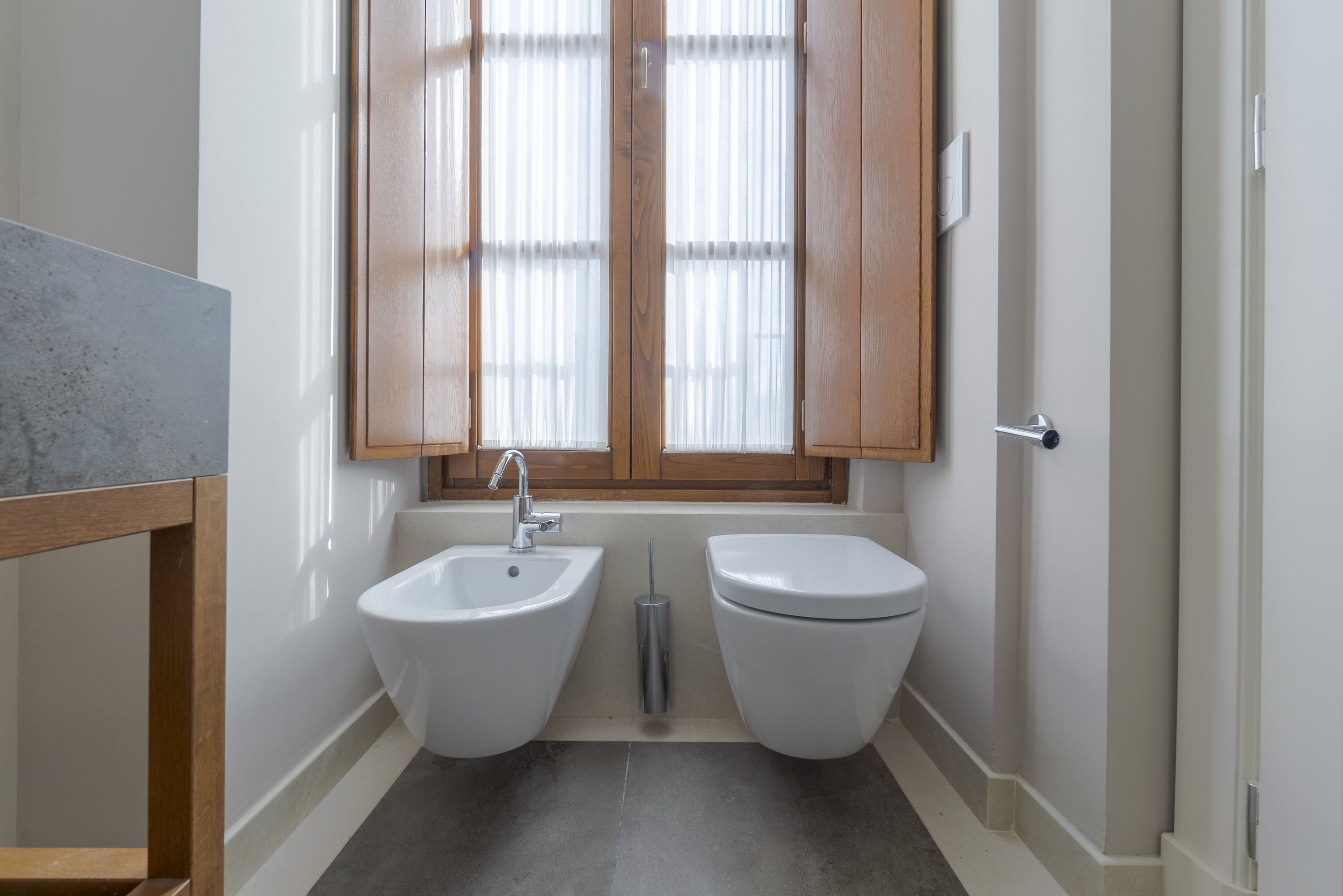A bathroom with a bidet, a sink, and a toilet.