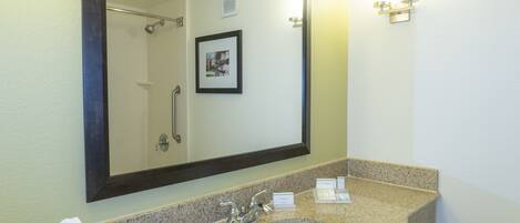 Une salle de bain avec un lavabo, un miroir et une douche.