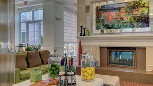 A lobby with a green sofa, a fireplace, and various decorative items including jars of lemons and green apples. - Hilton Garden Inn Norwalk (Norwalk)