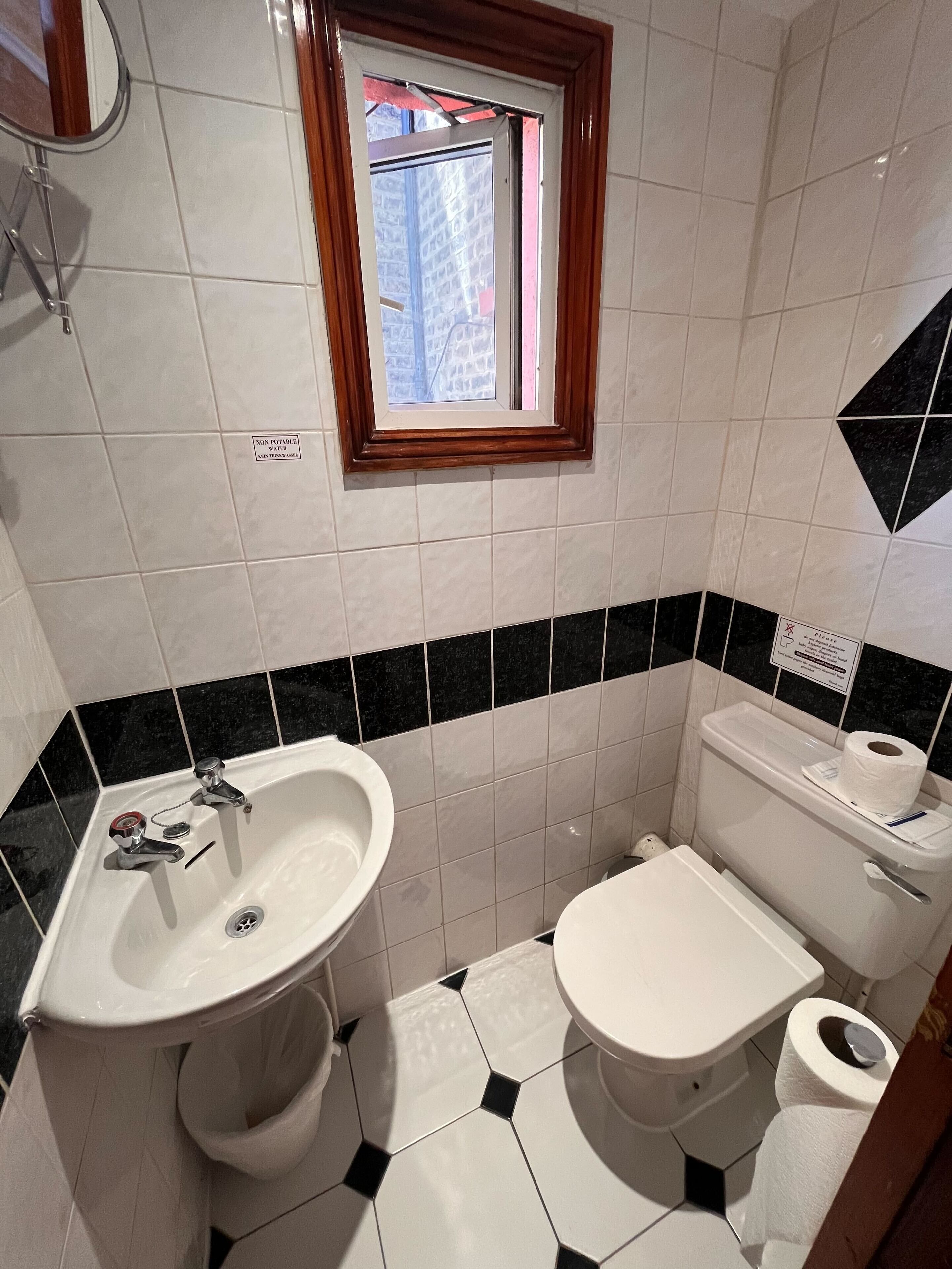 Ein Badezimmer mit Waschbecken, Toilette und einem Fenster.