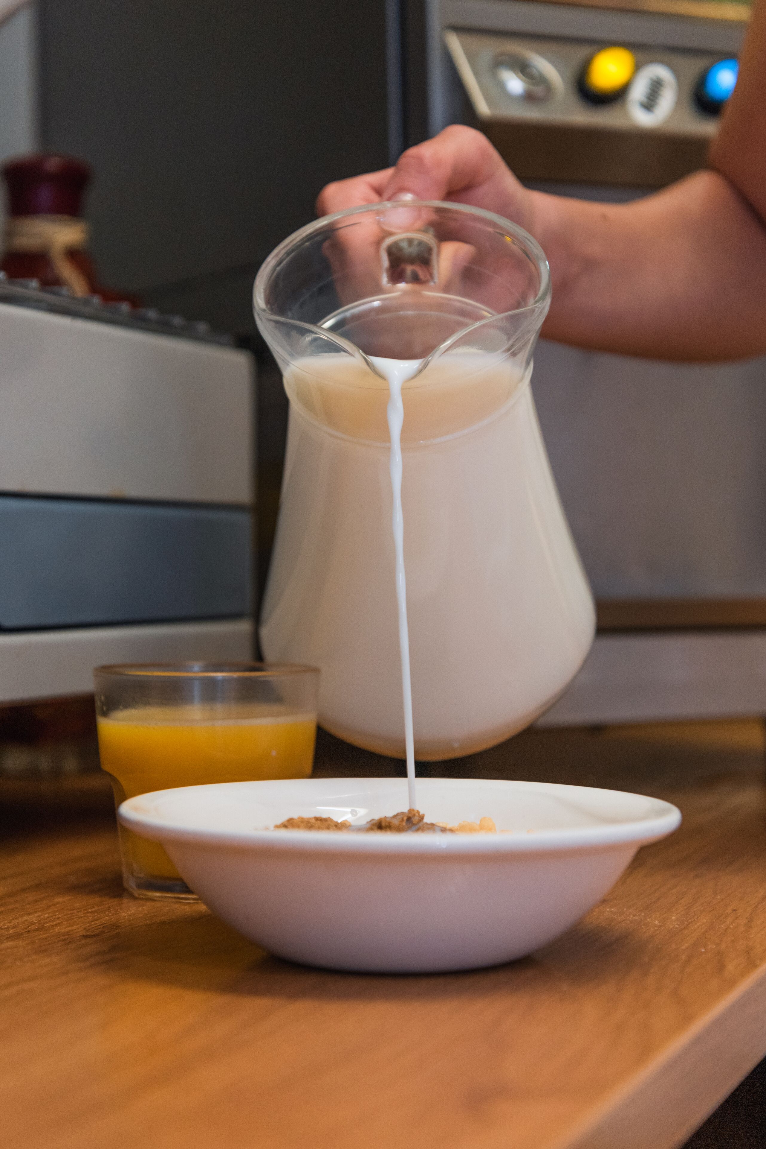 Eine Person gießt Milch in eine Schüssel.