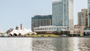 Vista panorámica del frente marítimo de una ciudad con edificios modernos, incluyendo una estructura blanca distintiva con un diseño de techo único.
