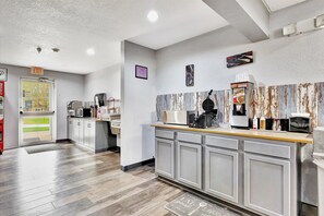 A modern kitchen with a built-in waffle maker, a coffee machine, and a microwave. - Ramada Limited Bloomington IL I-74/I-55 (Bloomington)