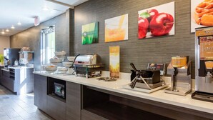 A hotel breakfast area with a self-service counter, coffee machines, and a waffle maker. - Quality Inn & Suites Ashland near Kings Dominion (Ashland)