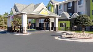 A multi-story hotel with a covered entrance and a landscaped driveway. - Quality Inn & Suites Ashland near Kings Dominion (Ashland)