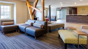 A modern lobby with a reception desk, seating area, and a visible staircase. - Quality Inn & Suites Ashland near Kings Dominion (Ashland)