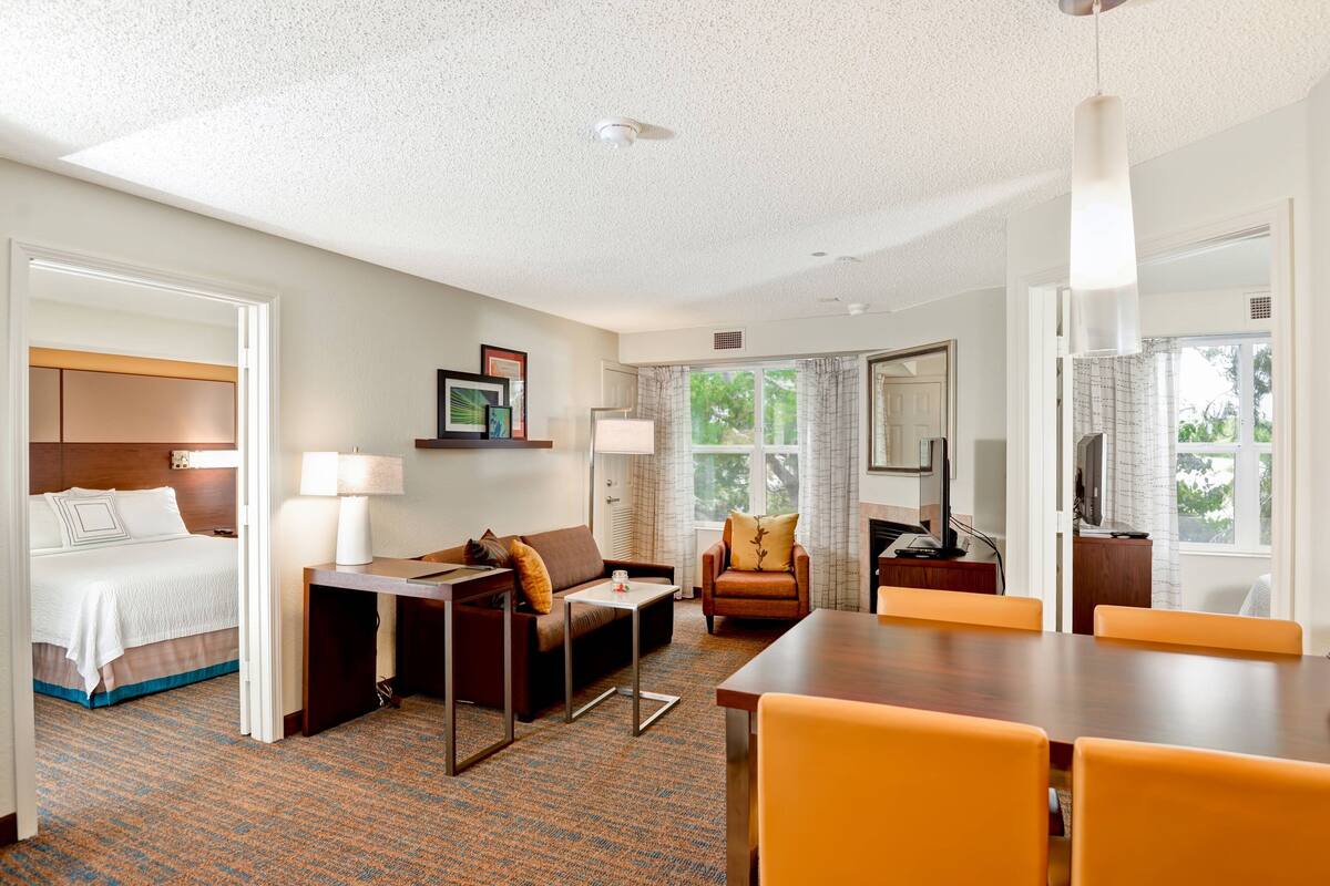 Une chambre d’hôtel comprenant un lit, un canapé, une table à manger et un téléviseur.