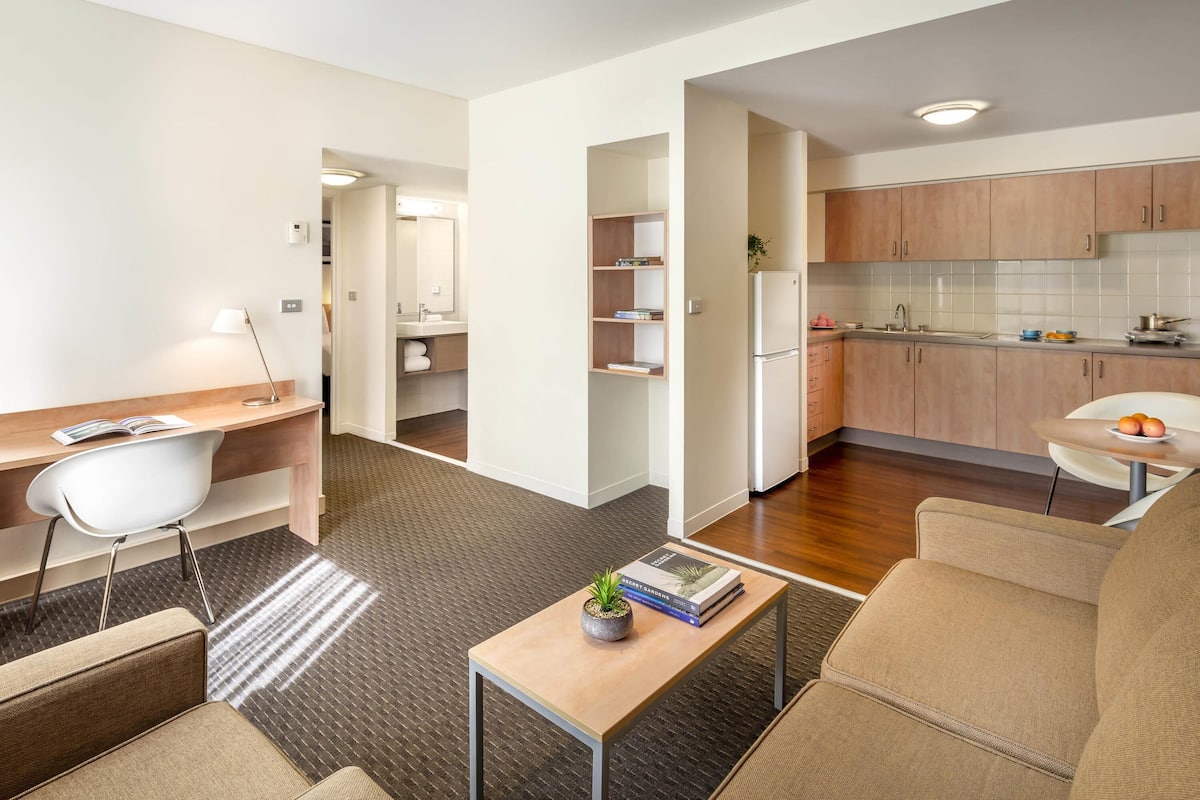 Un apartamento moderno con sala de estar, cocina y un pequeño comedor.