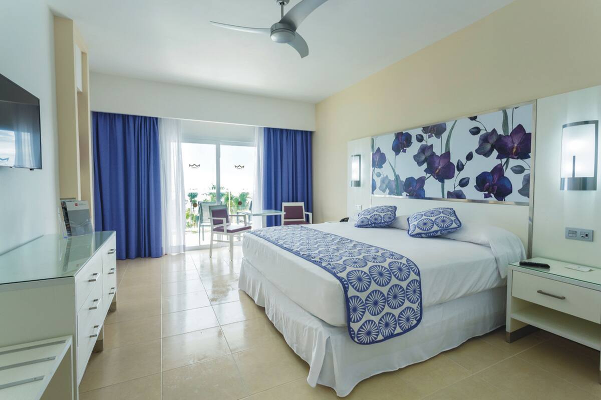 Una habitación de hotel con una cama, un escritorio, una silla y un televisor.