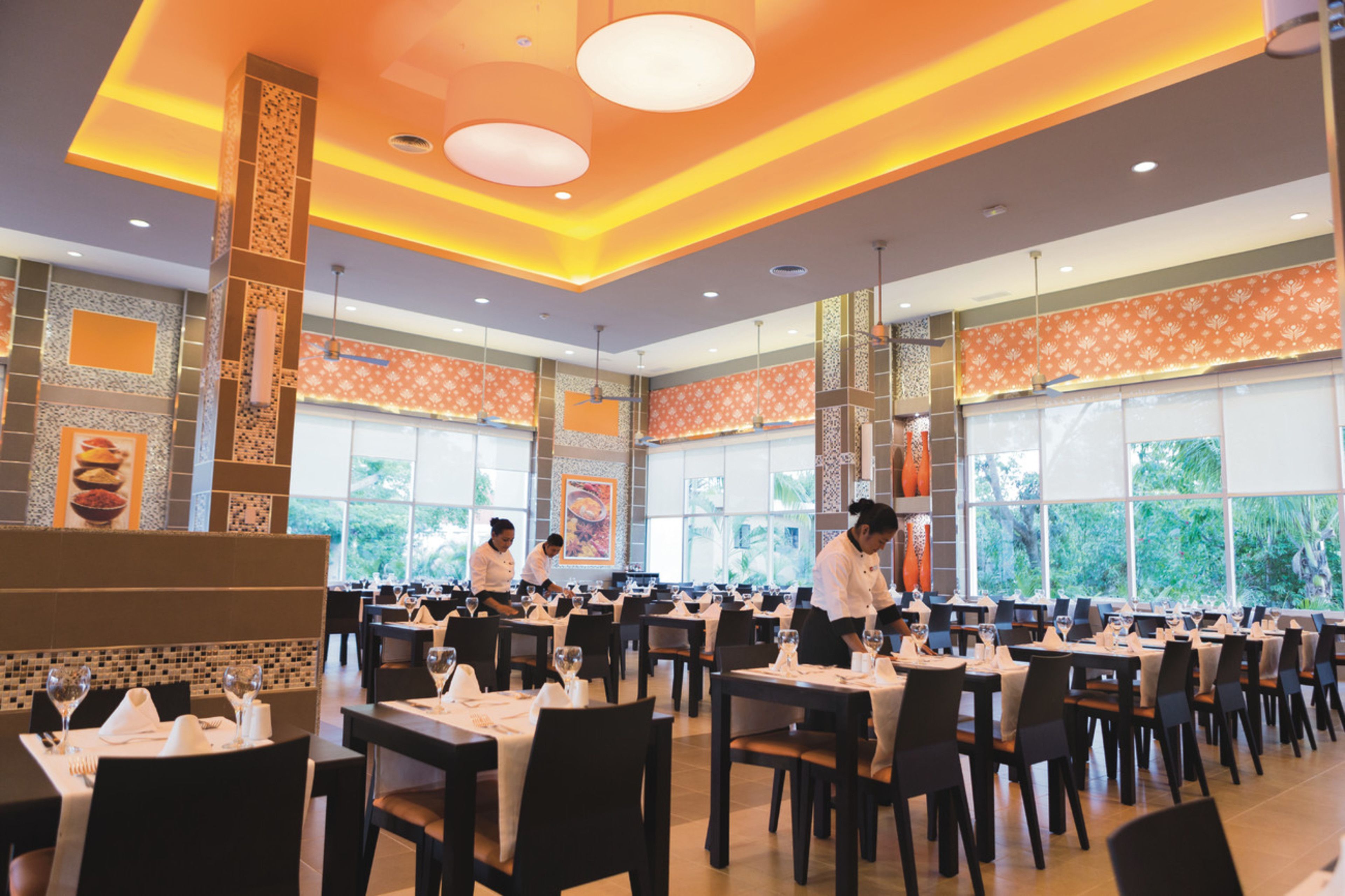 A spacious restaurant with high ceilings, large windows, and a modern interior design.