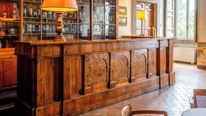 Une bibliothèque avec un bureau en bois, des étagères et une grande peinture au plafond.