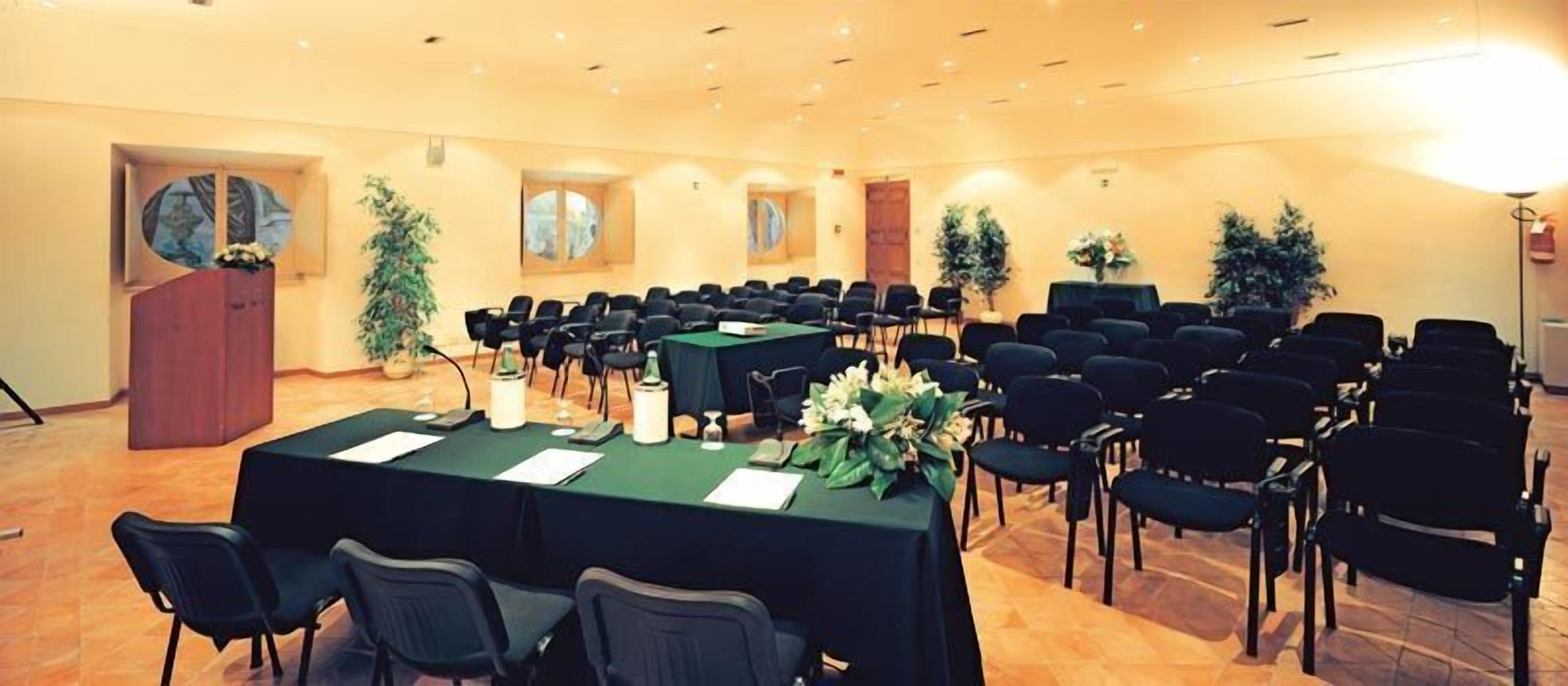 A conference room with a long table, chairs, and a podium.