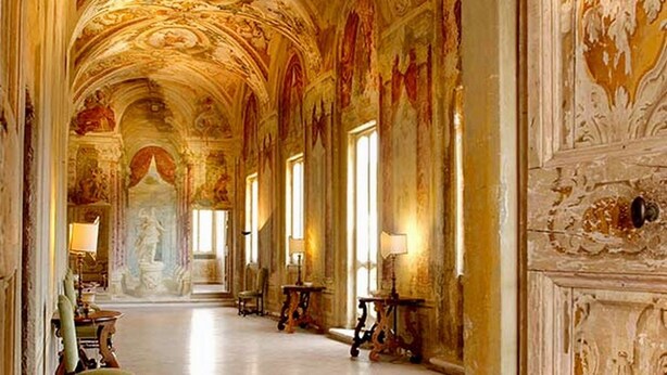 Un vaste hall d’entrée orné de fresques au plafond, doté d’un sol en marbre et de colonnes de style classique.