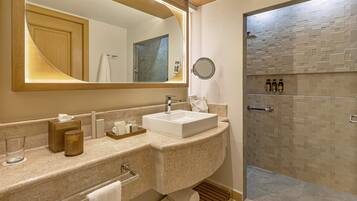 Un baño con un espejo grande, un lavabo y zona de ducha.