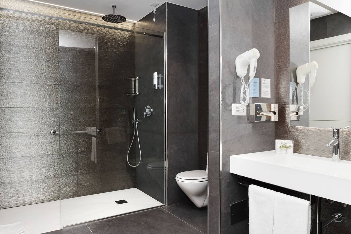 junior suite | bathroom | shower, hair dryer, bidet, towels