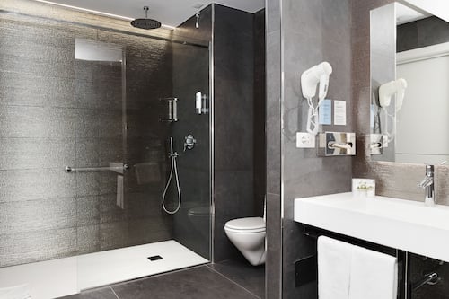 Junior suite | Badkamer | Een douche, een haardroger, een bidet, handdoeken