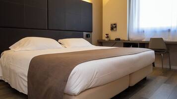 Een moderne hotelkamer met een groot bed, een bureau en een stoel.