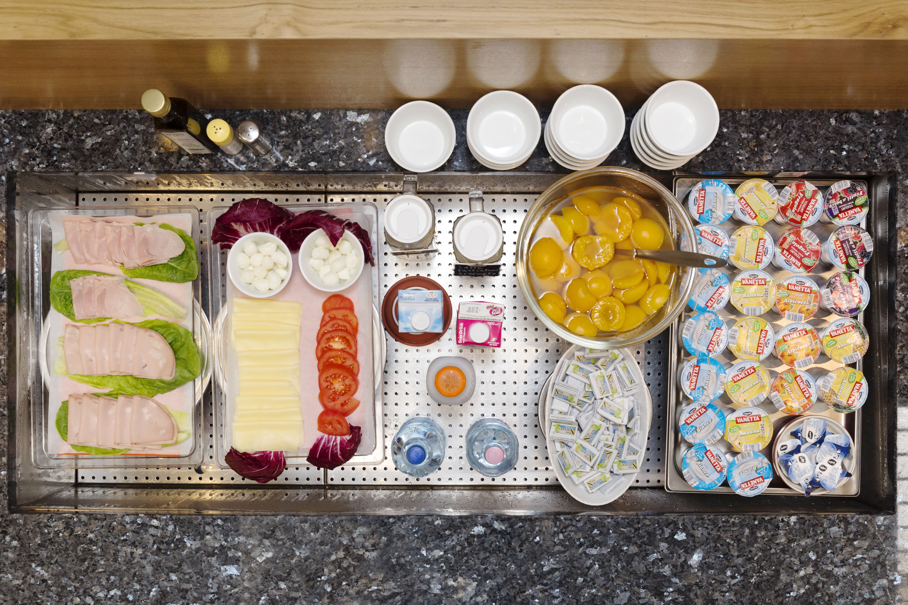 A buffet setup with various food items and condiments.